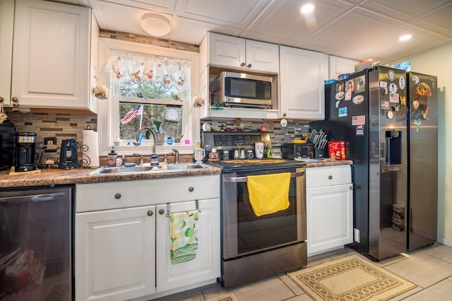 kitchen with stainless steel appliances, a sink, decorative backsplash, white cabinetry, and recessed lighting