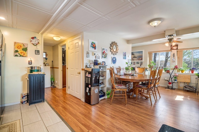 dining space featuring a ceiling fan, light wood finished floors, and baseboards