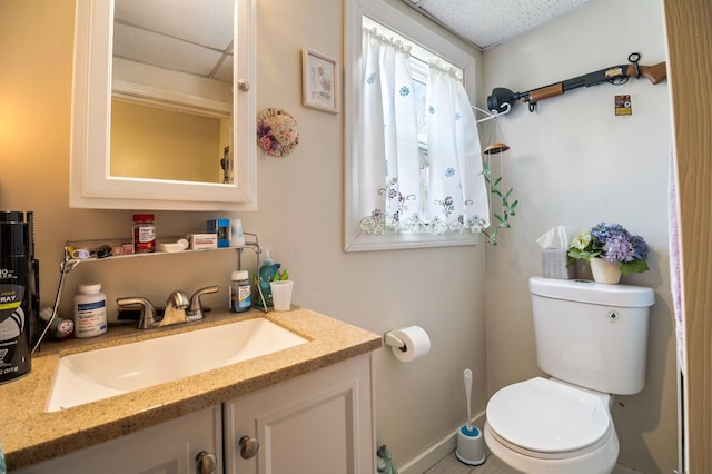 half bath with toilet, vanity, and baseboards