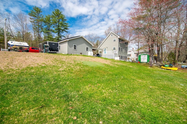 view of grassy yard featuring a shed and an outbuilding
