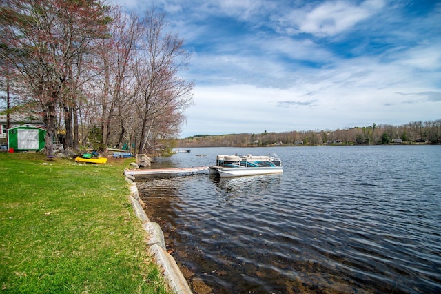 dock area with a water view and a yard