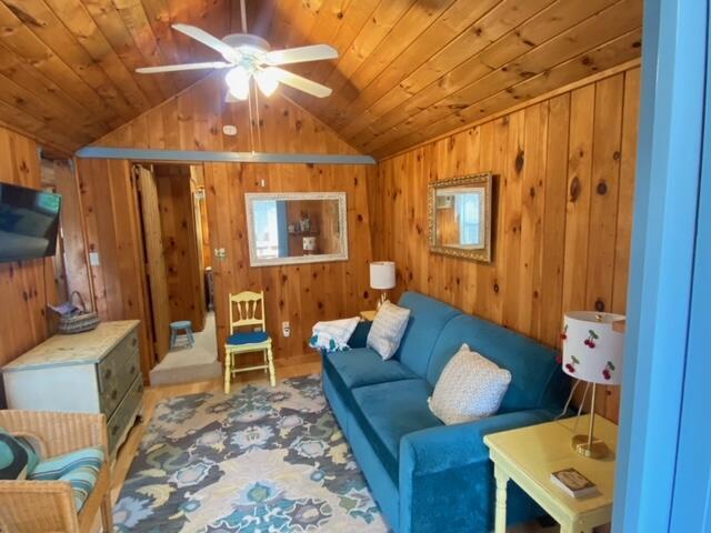 76 Post Rd Unit C9, Wells, ME 04090 - living room featuring vaulted ceiling, ceiling fan, wood walls, and wood ceiling