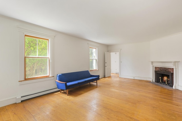 44 Pascal Ave, Rockport, ME 04856 - sitting room with a baseboard radiator, light wood-style floors, a brick fireplace, and baseboard heating