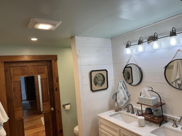 1363 Hallowell Rd, Litchfield, ME 04350 - bathroom with wood finished floors, toilet, double vanity, and recessed lighting