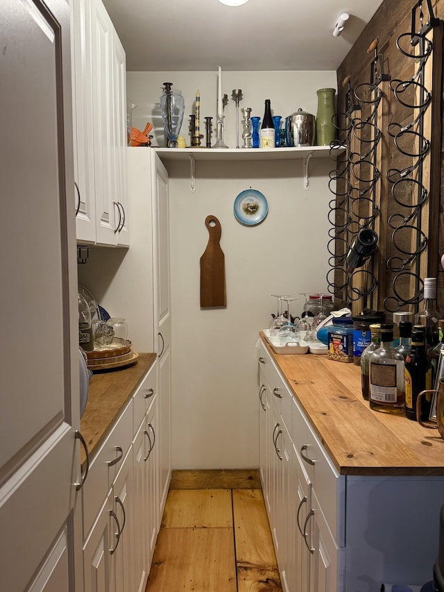 1363 Hallowell Rd, Litchfield, ME 04350 - kitchen featuring butcher block counters, light wood finished floors, white cabinetry, and open shelves