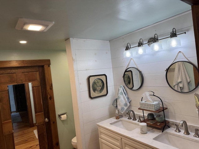 1363 Hallowell Rd, Litchfield, ME 04350 - bathroom with double vanity, toilet, wood finished floors, and recessed lighting