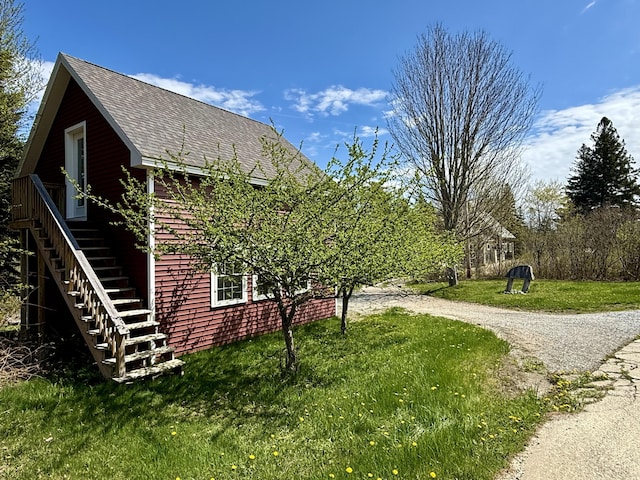 26 Hamilton Dr, Vinalhaven, ME 04863 - view of side of home featuring roof with shingles, a yard, stairs, and driveway