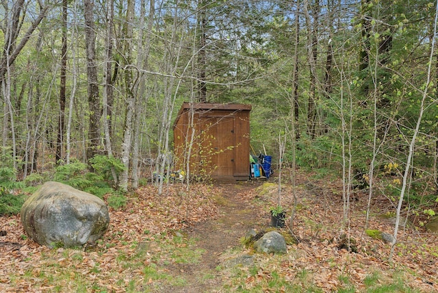 view of shed featuring a view of trees