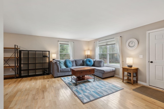 living area featuring light wood-style floors and baseboards