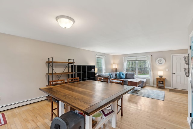 dining area featuring a baseboard radiator and light wood-type flooring