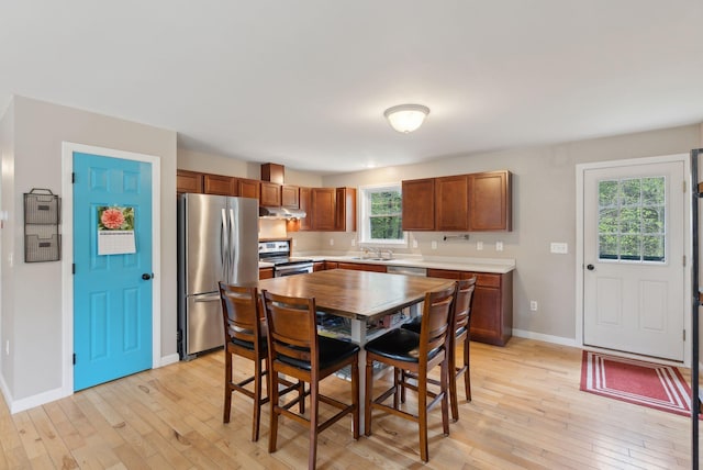 dining area with light wood-type flooring and baseboards