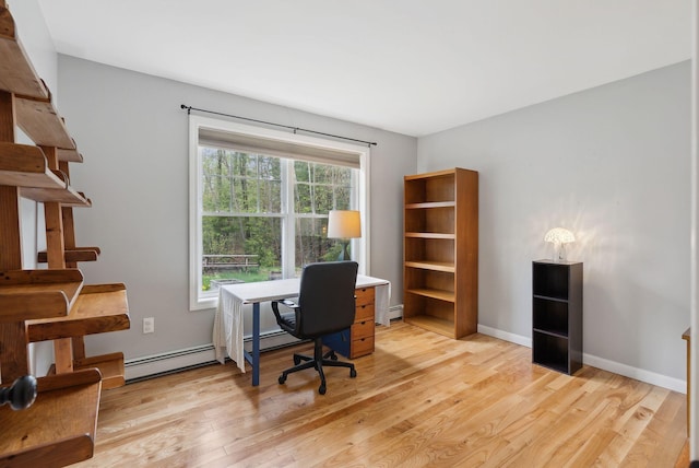 office area featuring light wood-style flooring, baseboard heating, baseboards, and a baseboard heating unit