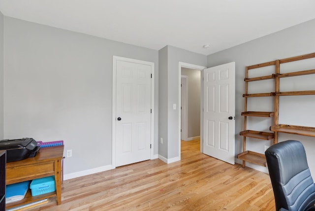 home office with light wood-type flooring and baseboards