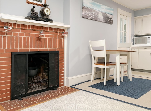 63 Fletcher St, Kennebunk, ME 04043 - detailed view of white microwave, a fireplace, baseboards, and crown molding