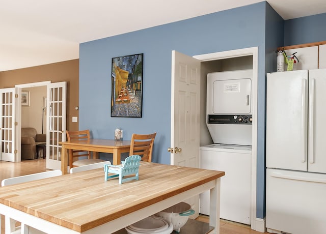 63 Fletcher St, Kennebunk, ME 04043 - dining space featuring stacked washer and clothes dryer, french doors, and light wood finished floors