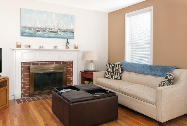 63 Fletcher St, Kennebunk, ME 04043 - living area featuring light wood finished floors and a brick fireplace