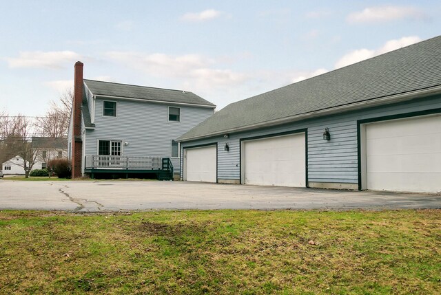 63 Fletcher St, Kennebunk, ME 04043 - view of property exterior with a garage, an outdoor structure, a chimney, and a lawn