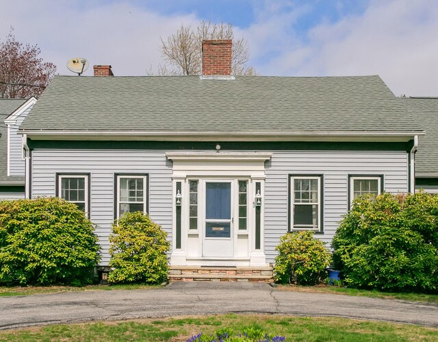 63 Fletcher St, Kennebunk, ME 04043 - view of front facade featuring entry steps, a chimney, and a shingled roof