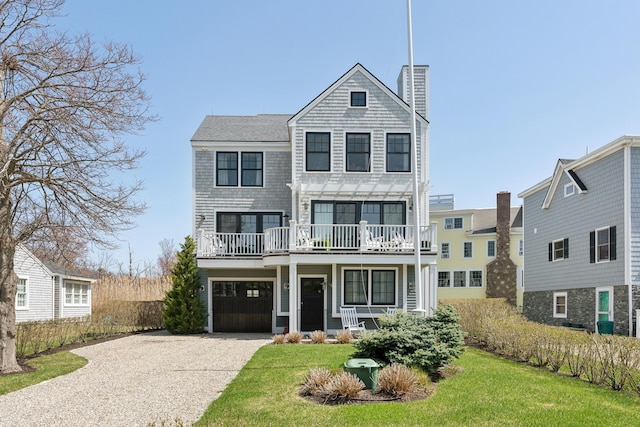 1 Harris Ln, Kennebunk, ME 04043 - view of front of house featuring driveway, a chimney, a front yard, and a balcony