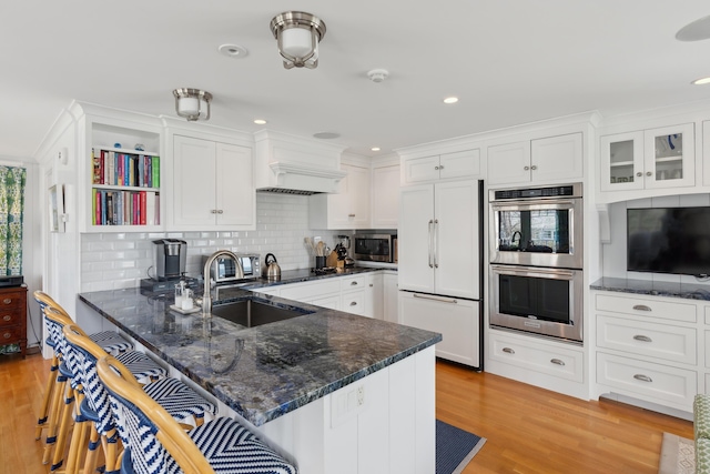 1 Harris Ln, Kennebunk, ME 04043 - kitchen with a breakfast bar area, a sink, white cabinetry, a peninsula, and appliances with stainless steel finishes
