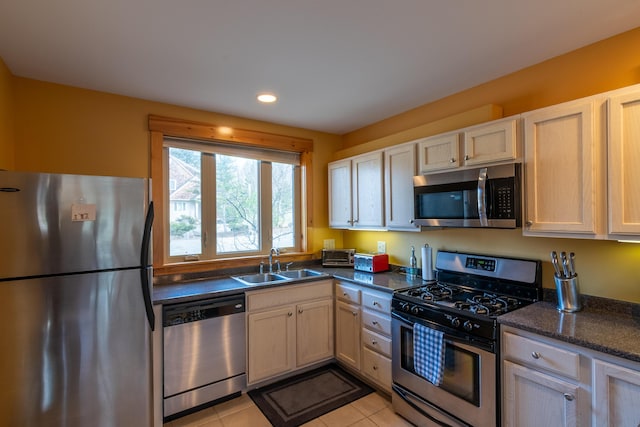 kitchen featuring recessed lighting, light tile patterned flooring, appliances with stainless steel finishes, and a sink