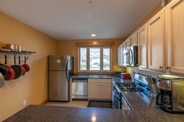 kitchen with a sink, recessed lighting, dark countertops, and appliances with stainless steel finishes