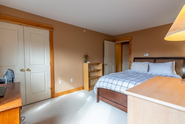carpeted bedroom with baseboards and a closet