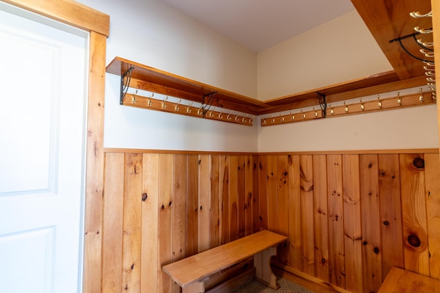 mudroom with wooden walls and wainscoting