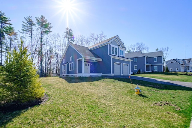 view of front of property featuring a garage, a front yard, and driveway