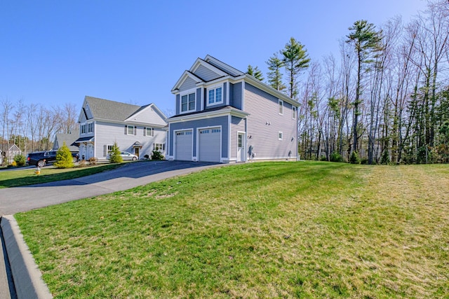 view of front of home featuring driveway, an attached garage, and a front yard