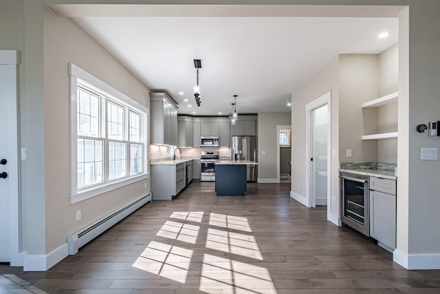 kitchen featuring a baseboard heating unit, stainless steel appliances, gray cabinets, beverage cooler, and dark wood-type flooring