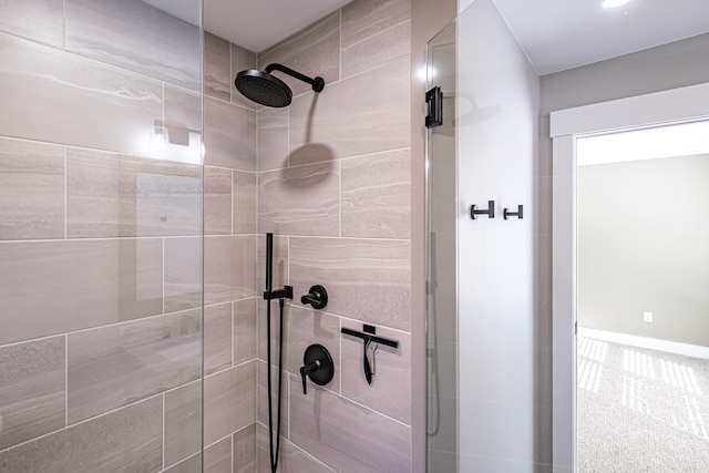 bathroom featuring a shower stall and baseboards