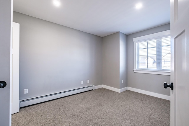 carpeted empty room with baseboard heating and baseboards