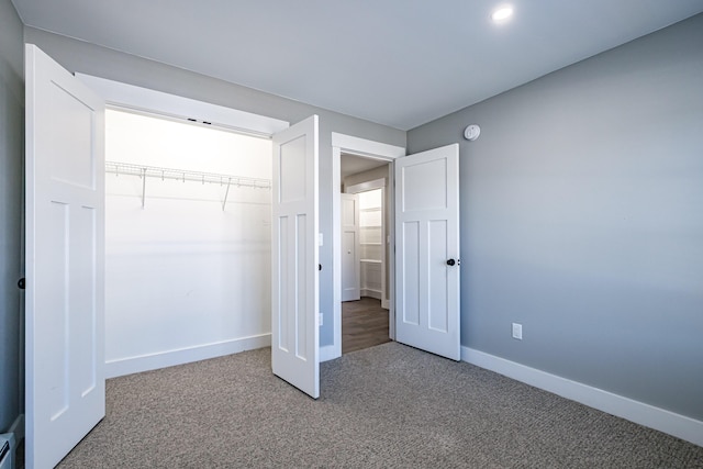 unfurnished bedroom with carpet, baseboards, and a closet