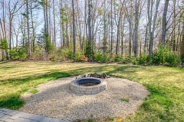 view of grassy yard with an outdoor fire pit