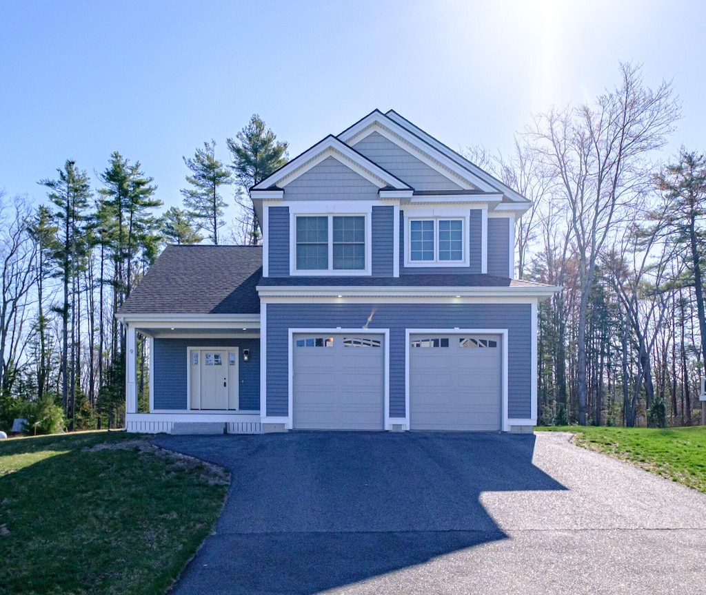 9 Winn Way, Scarborough, ME 04074 - view of front of house featuring asphalt driveway, a garage, a porch, and a front lawn