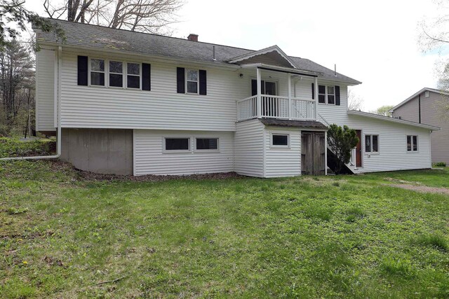 back of house with stairs, a lawn, and a chimney