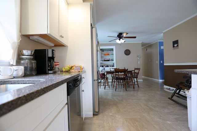 kitchen with appliances with stainless steel finishes, crown molding, a ceiling fan, white cabinets, and dark stone countertops