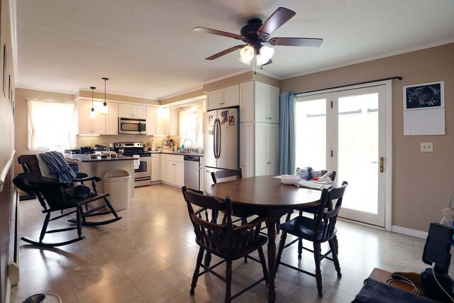 dining area with ornamental molding, healthy amount of natural light, a ceiling fan, and baseboards