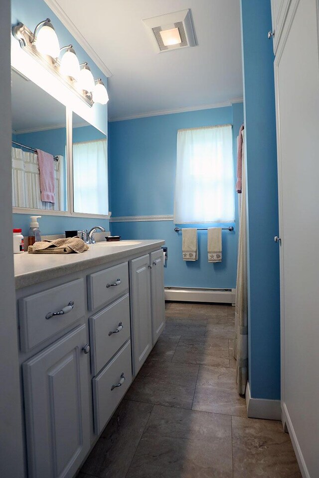 bathroom with a baseboard radiator, vanity, baseboards, and ornamental molding