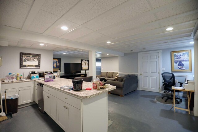 kitchen featuring a peninsula, white cabinetry, open floor plan, dishwasher, and concrete flooring