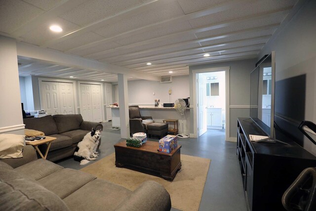 living area featuring concrete floors, recessed lighting, and baseboards