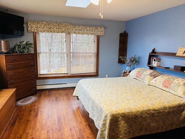 71 Reynolds Rd, Brooks, ME 04921 - bedroom with a baseboard radiator, wood finished floors, and a skylight