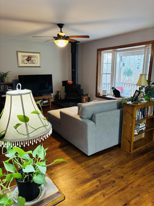 71 Reynolds Rd, Brooks, ME 04921 - living room with a wood stove, ceiling fan, and wood finished floors