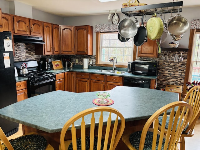 71 Reynolds Rd, Brooks, ME 04921 - kitchen featuring a sink, black appliances, under cabinet range hood, and decorative backsplash