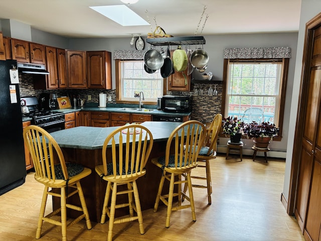 71 Reynolds Rd, Brooks, ME 04921 - kitchen with a skylight, black appliances, healthy amount of natural light, and tasteful backsplash
