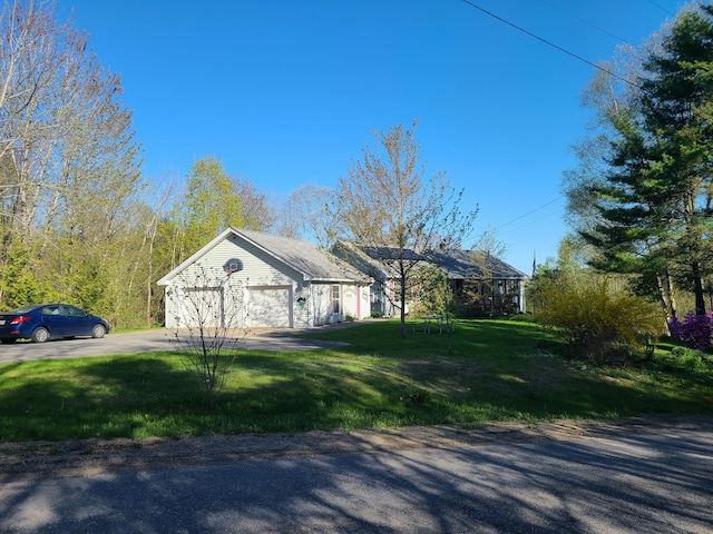 71 Reynolds Rd, Brooks, ME 04921 - view of side of home with an attached garage, driveway, and a lawn