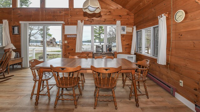 676 S High St, Bridgton, ME 04009 - dining area with lofted ceiling, a wealth of natural light, baseboard heating, and wood walls