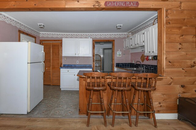 676 S High St, Bridgton, ME 04009 - kitchen featuring a peninsula, freestanding refrigerator, dark countertops, white cabinetry, and high end refrigerator