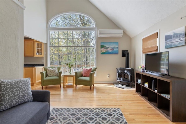 25 Sawmill Ln, Ogunquit, ME 03907 - living area with an AC wall unit, high vaulted ceiling, a wood stove, and wood finished floors